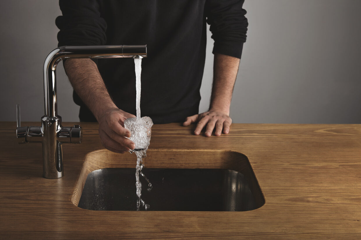 Barista rinses small glass with water